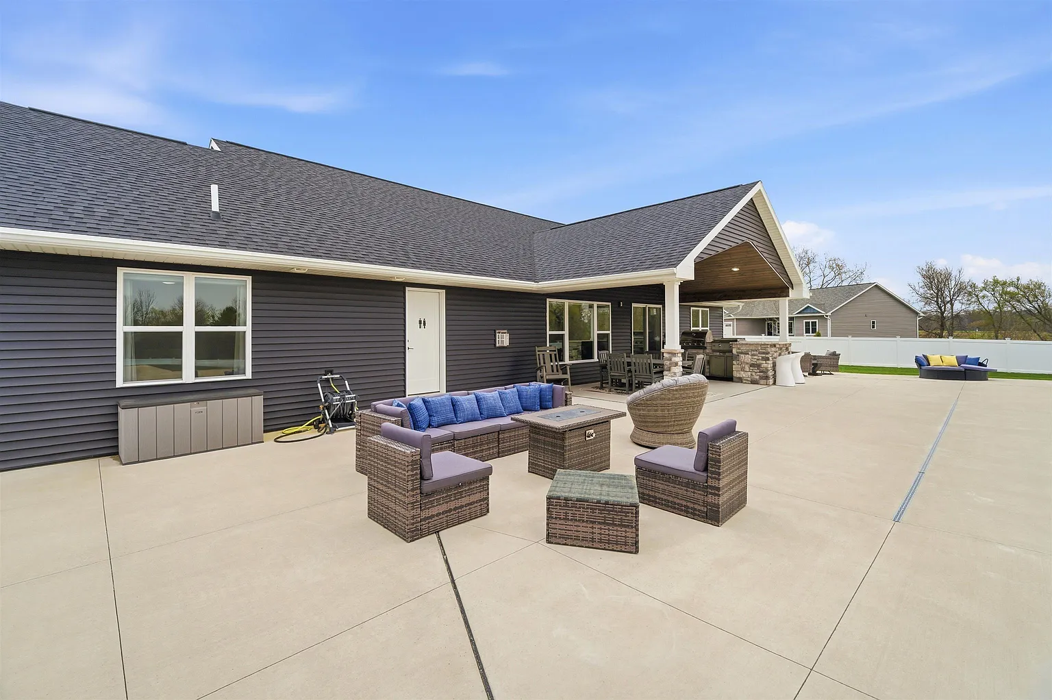 Outdoor kitchen with grill and wicker lounge