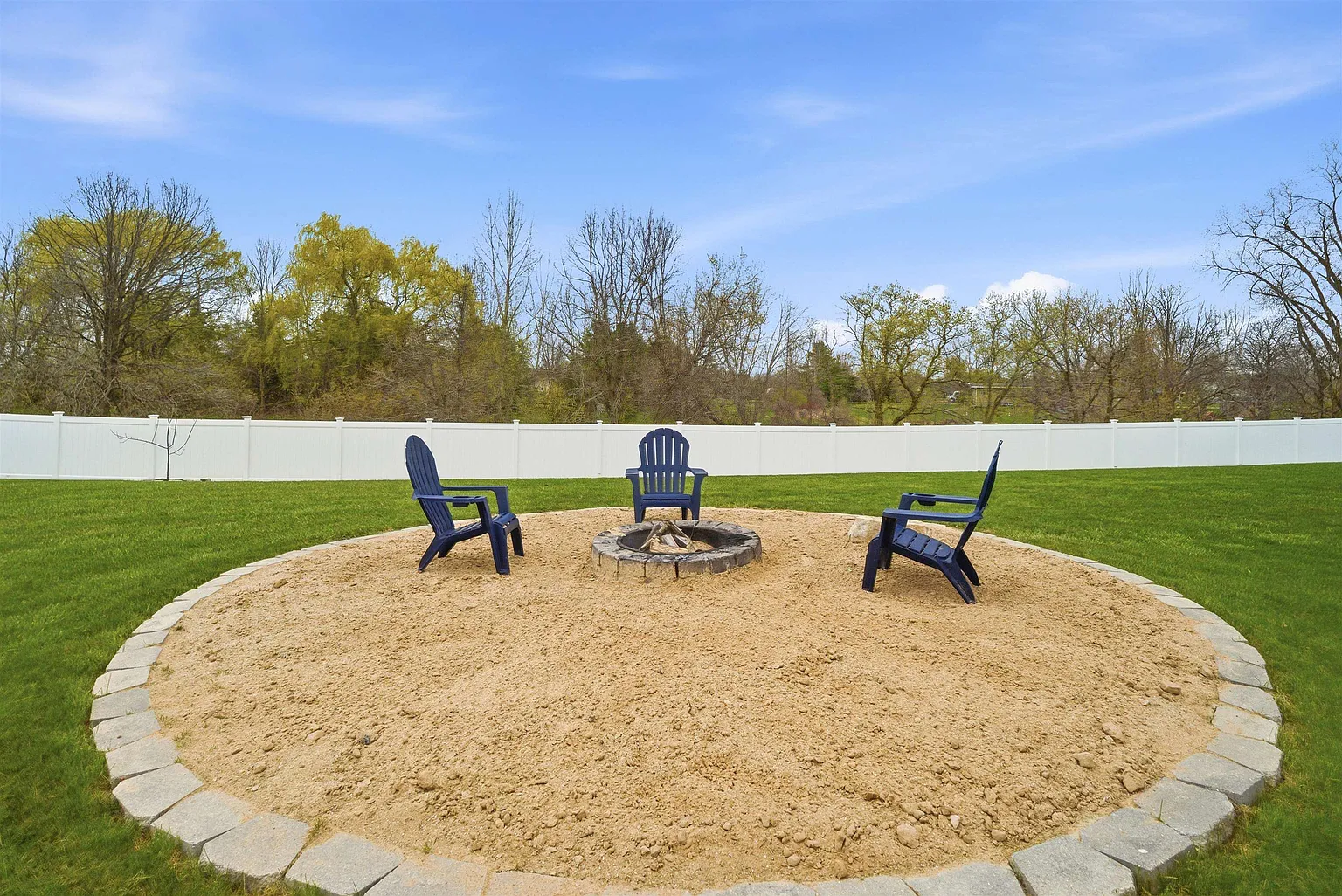 Stone-edged fire pit with Adirondack chairs