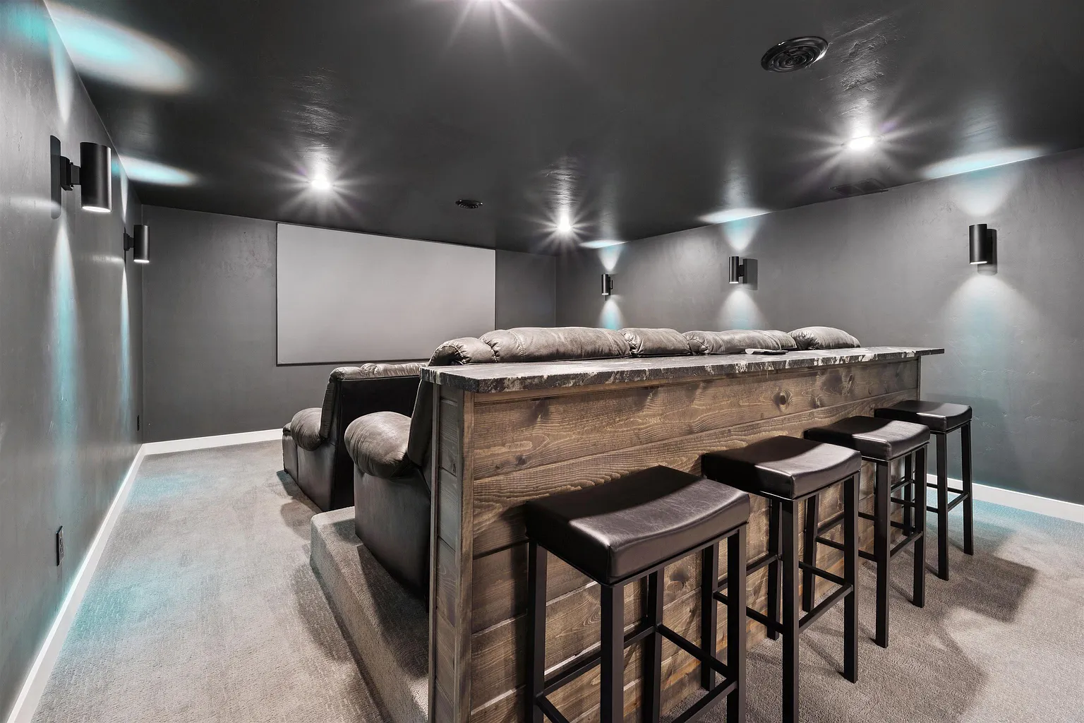 Home theater with tiered seating and projector screen